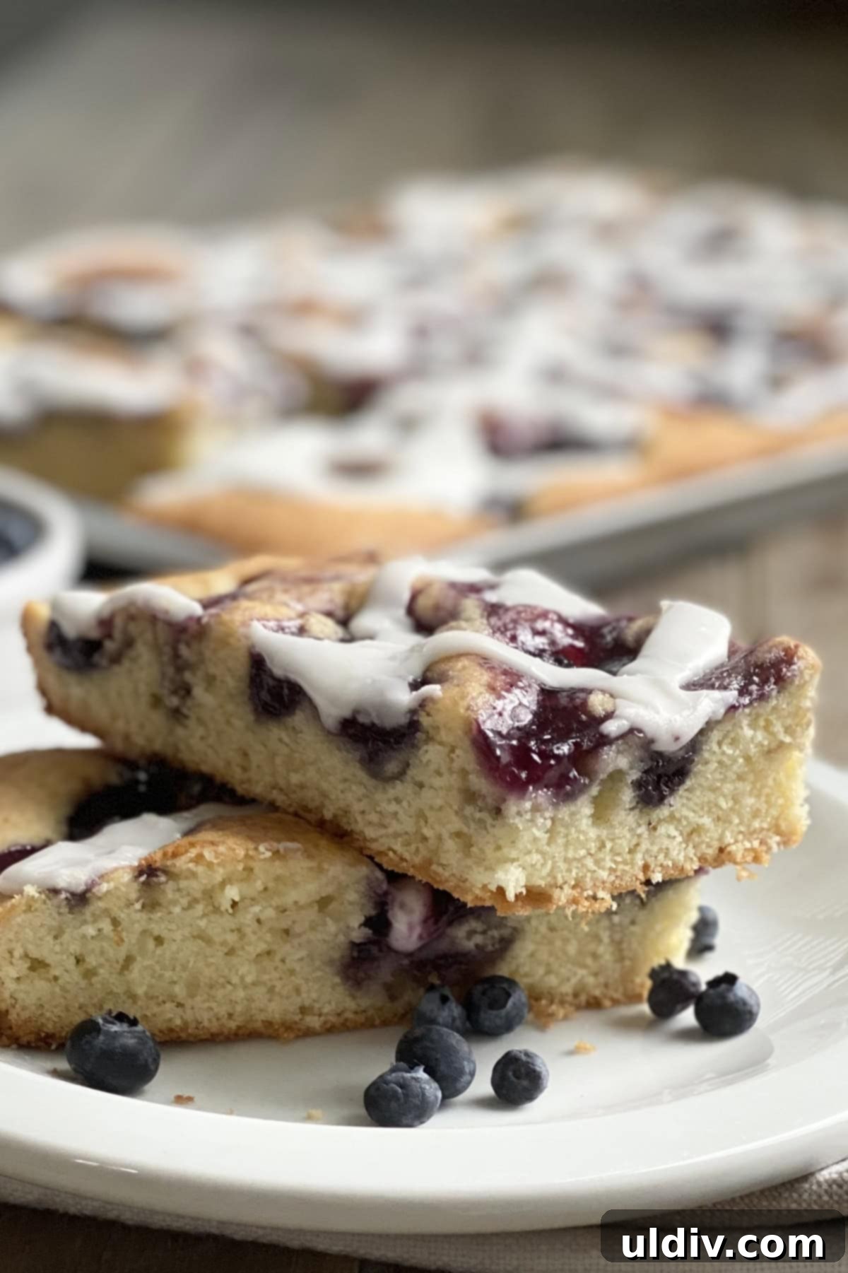 One-Pan Scone Cake 2 Two slices of delicious Scone Breakfast Cake with a sweet glaze, perfect for any morning.