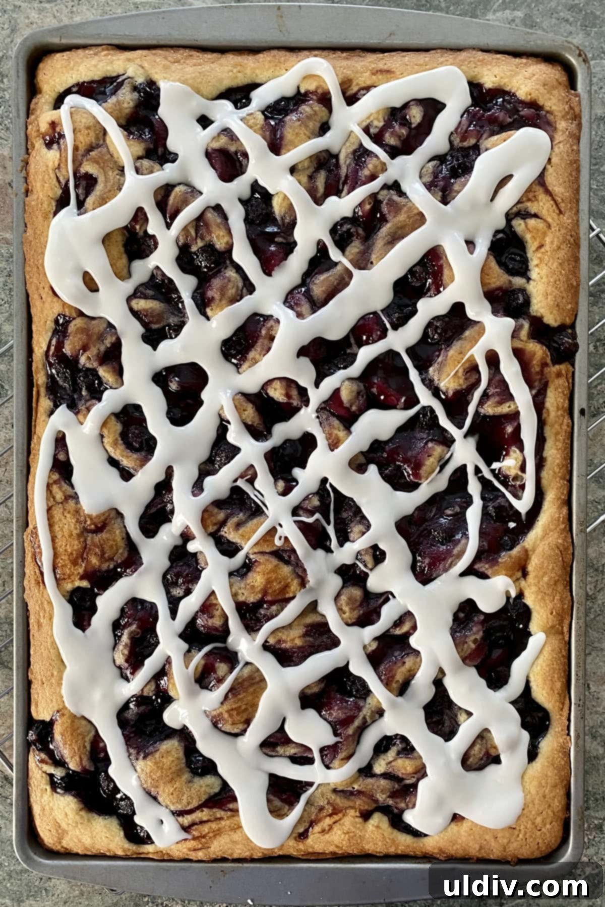 One-Pan Scone Cake 3 A sheet pan filled with a baked scone cake, generously studded with blueberries.