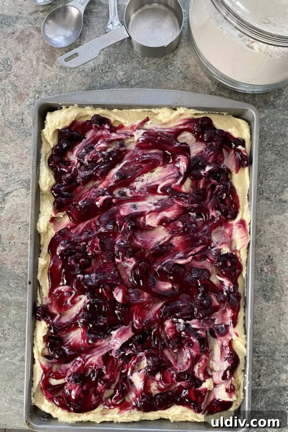 One-Pan Scone Cake 4 Cake batter for a scone breakfast cake with a vibrant blueberry pie filling swirl, ready for baking.