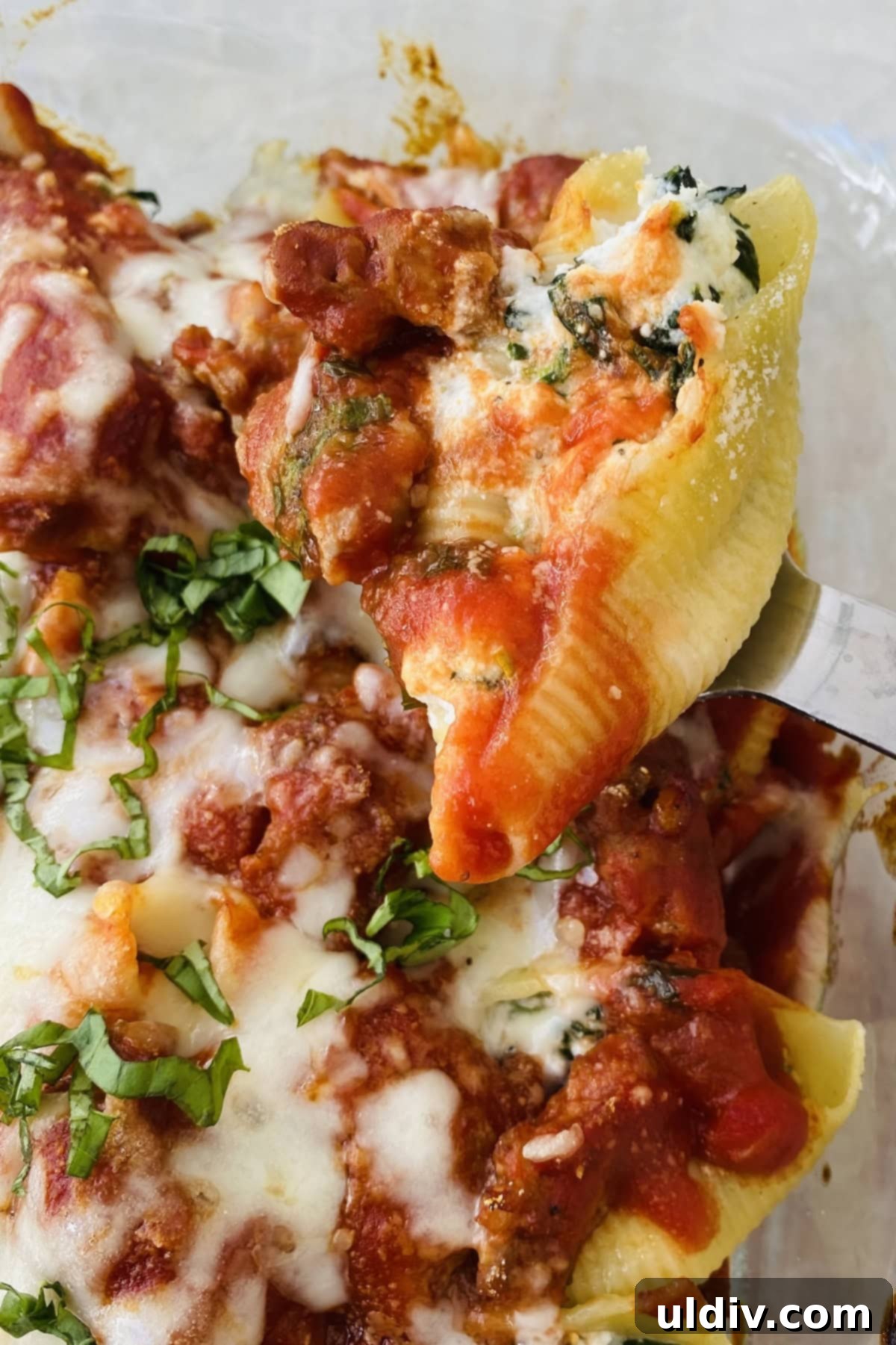 Hearty Italian Sausage Stuffed Shells 2 spoon with a stuffed pasta shell, showcasing the rich filling and sauce