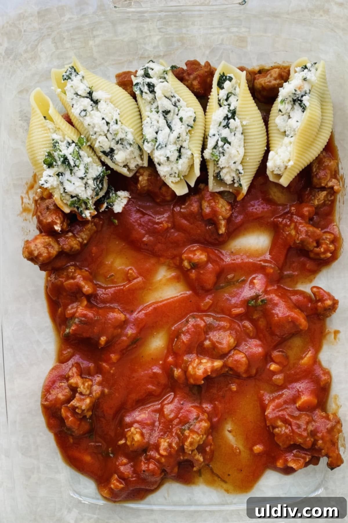 Hearty Italian Sausage Stuffed Shells 4 A hand expertly filling a jumbo pasta shell with the creamy cheese and spinach mixture