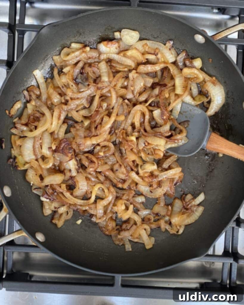 Classic French Onion Chicken Bake 4 Close-up of sliced Vidalia onions caramelizing in a pan, turning golden brown.