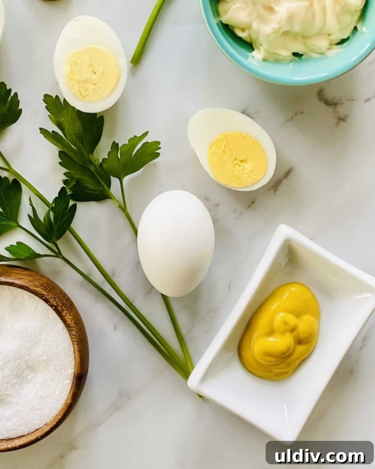 Jalapeno Fire Deviled Eggs 3 Close-up of fresh ingredients for spicy deviled eggs: hard-boiled eggs, a jar of pickled jalapenos, mayonnaise, mustard, kosher salt, pepper, smoked paprika, and fresh parsley sprigs.