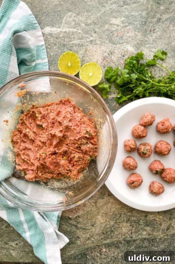 Spicy Red Thai Turkey Meatball Curry 5 Hands carefully forming small Thai turkey meatballs from the mixture on a clean surface.