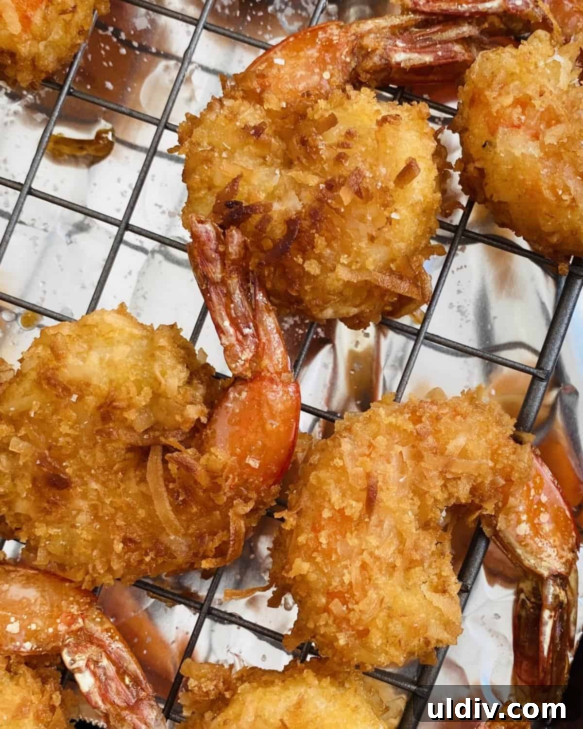 Tropical Coconut Crunch Shrimp 10 Freshly fried crispy coconut shrimp resting on a cooling rack