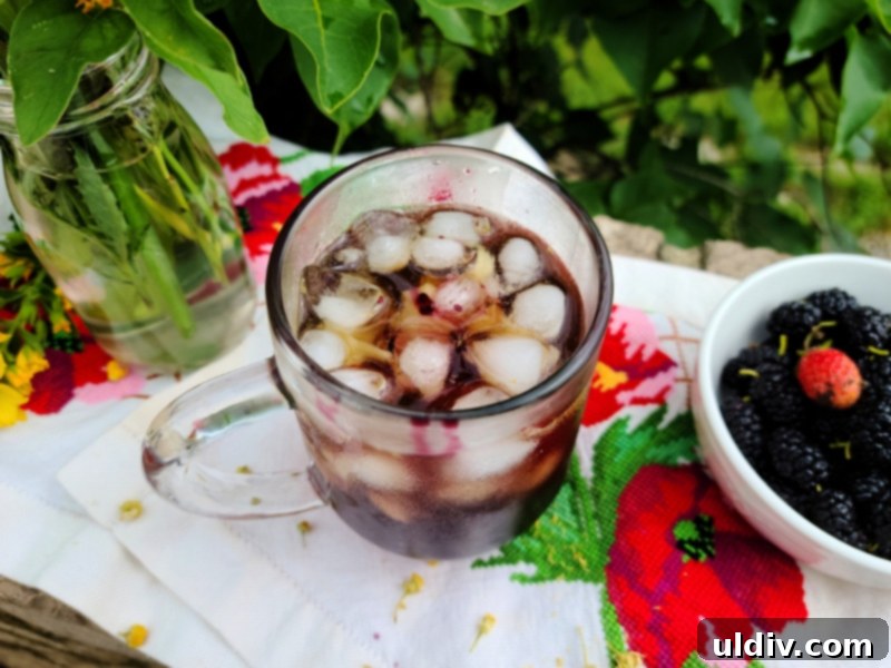 Refreshing iced chamomile tea with mulberry syrup, garnished with a mulberry