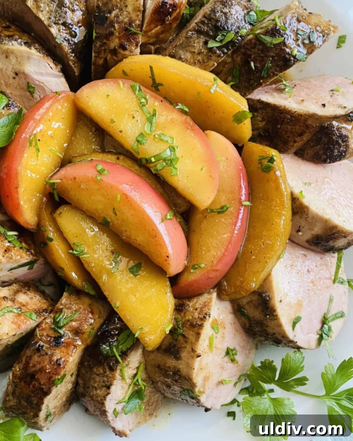 Maple Glazed Tenderloin with Caramelized Apples 2 Sautéed apples with maple glaze and pork tenderloin on a plate.