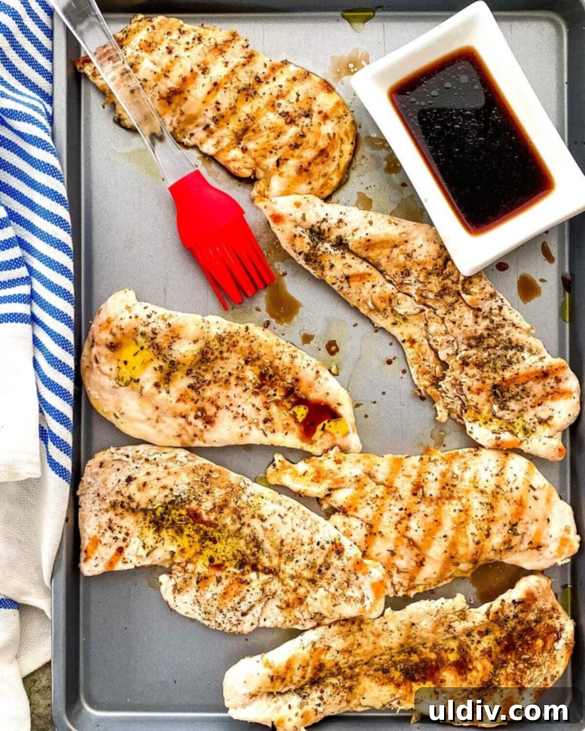 Vibrant Caprese Chicken Sandwich 5 A sheet pan with balsamic vinegar, grilled chicken and a basting brush.