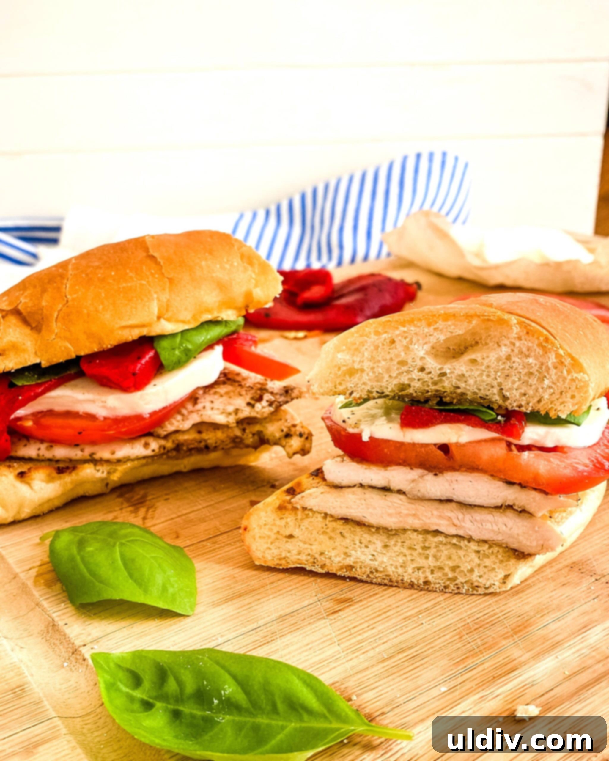 Vibrant Caprese Chicken Sandwich 9 A tomato mozzarella and chicken sandwich on a bun.