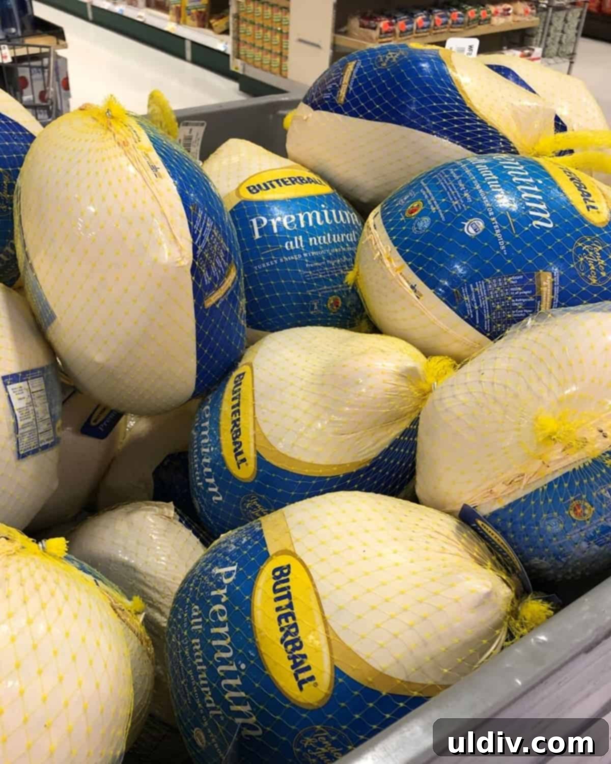 A large bin filled with frozen turkeys at a grocery store, ready for Thanksgiving preparations.