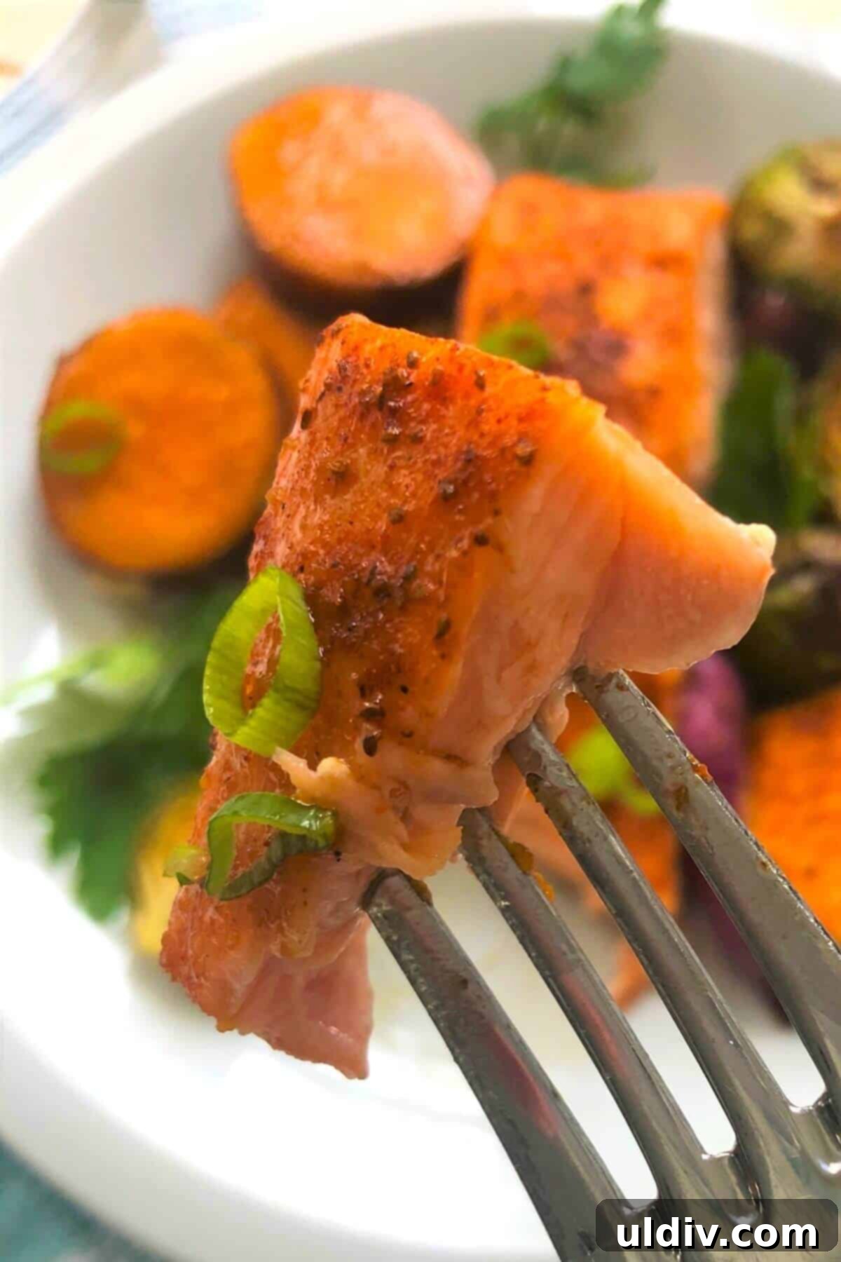 One-Pan Maple Salmon with Sweet Potatoes and Brussels Sprouts 7 a bite of salmon on a fork.