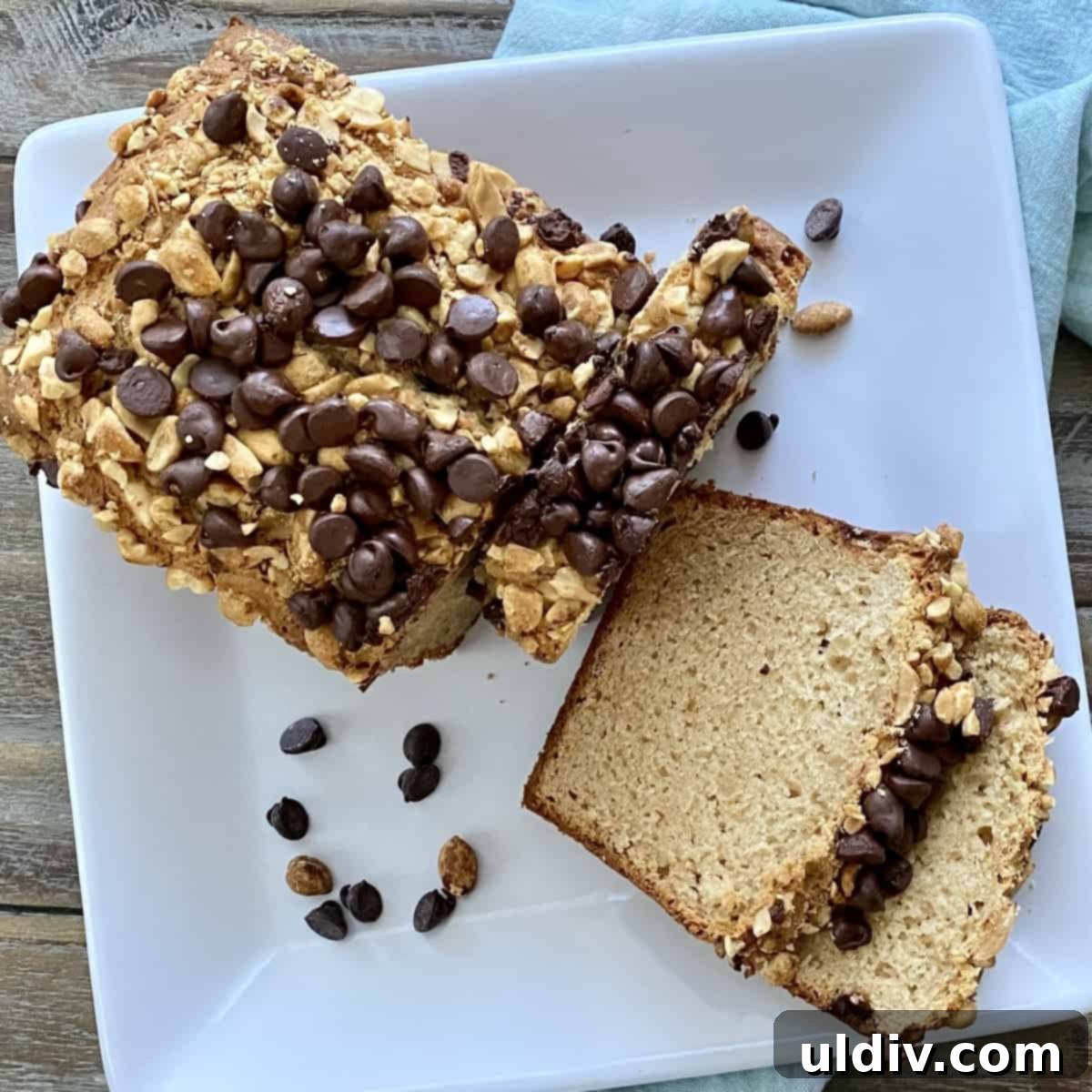 Double Peanut Chocolate Chip Loaf 12 Two slices of peanut butter bread next to half a loaf, topped with chocolate chips and peanuts.