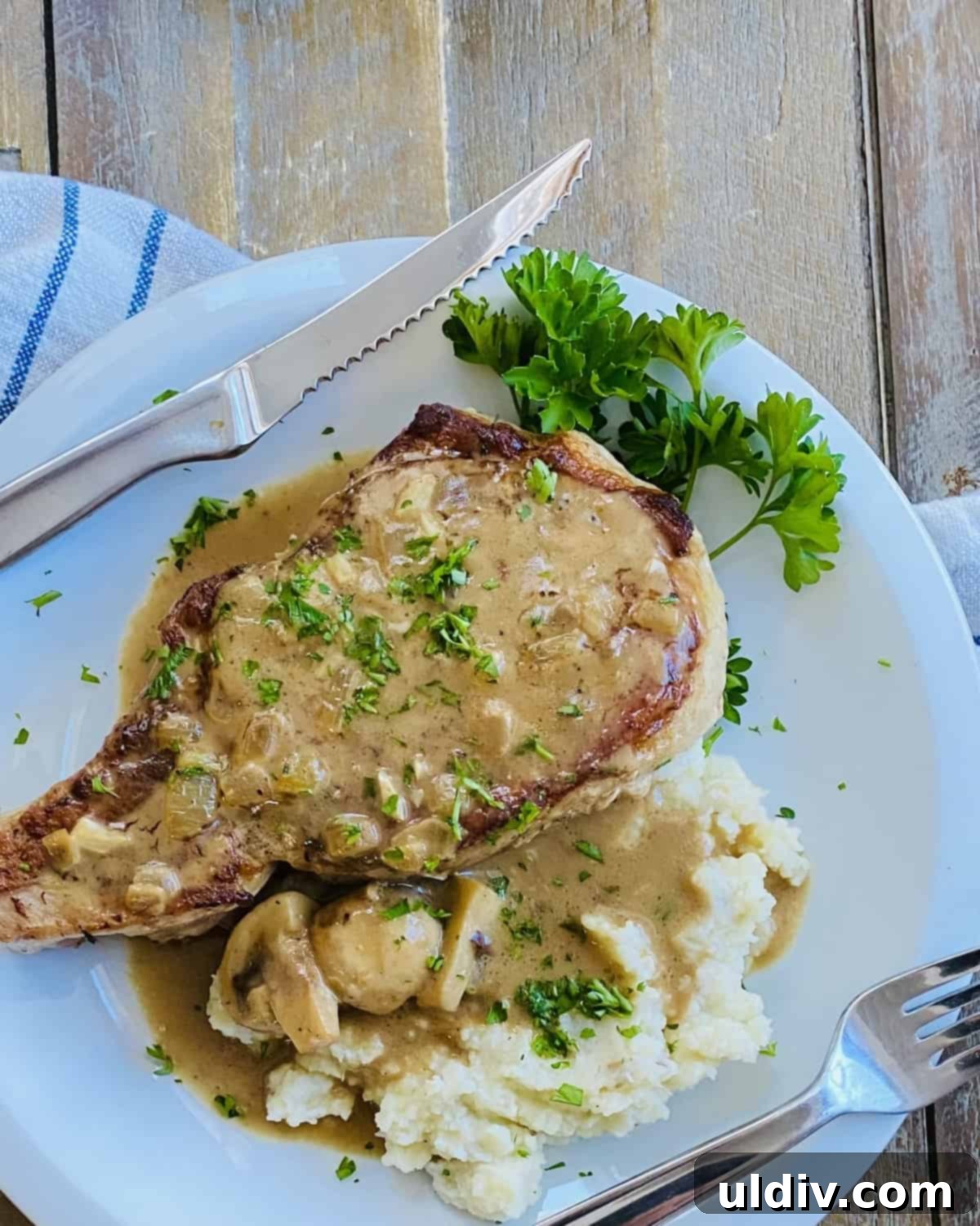 Golden Pork Chops Smothered in Creamy Mushroom Gravy 3 A bone-in pork chop with mushroom gravy over mashed potatoes.