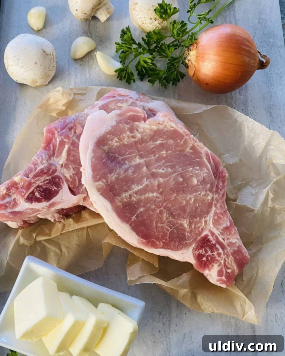 Golden Pork Chops Smothered in Creamy Mushroom Gravy 5 2 bone-in Berkshire pork chops on a counter.
