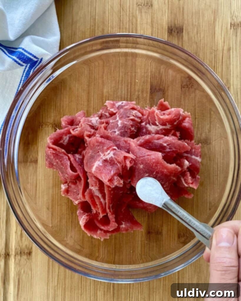 adding baking soda to sliced steak