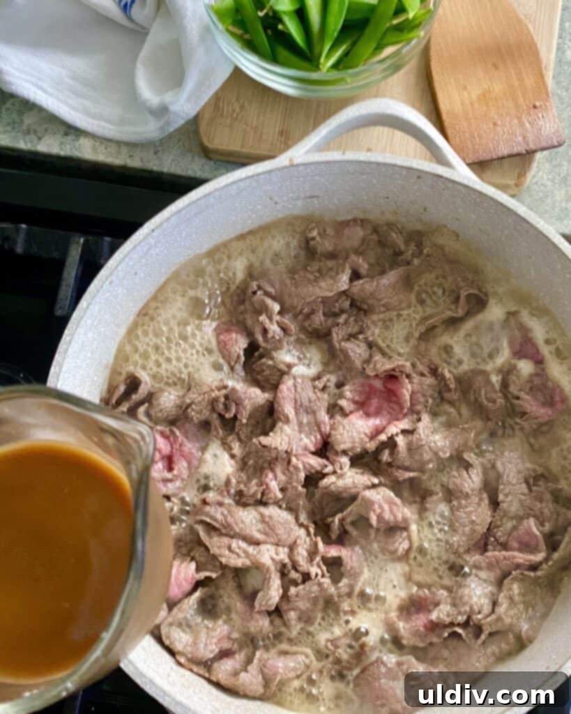 adding sauce to cooked steak for beef stir fry recipe