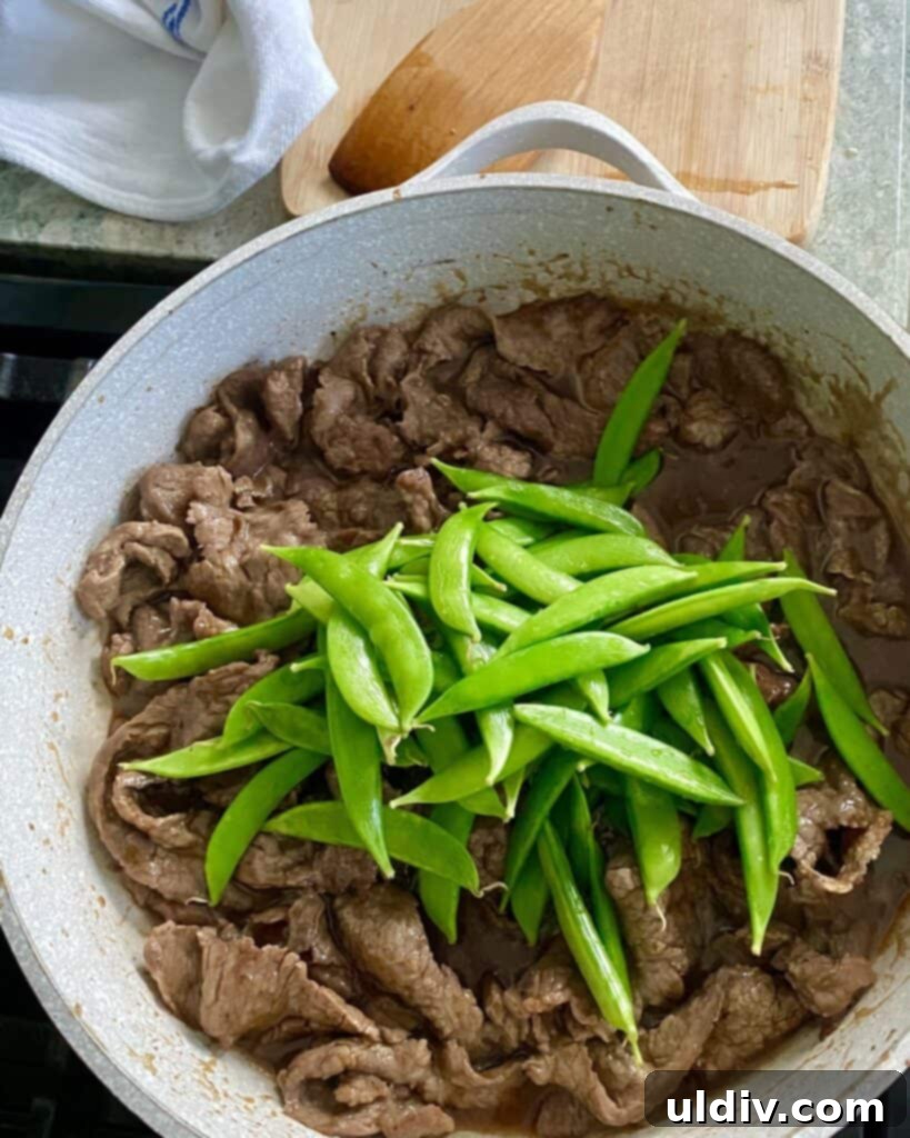 adding sugar snap peas to stir fry