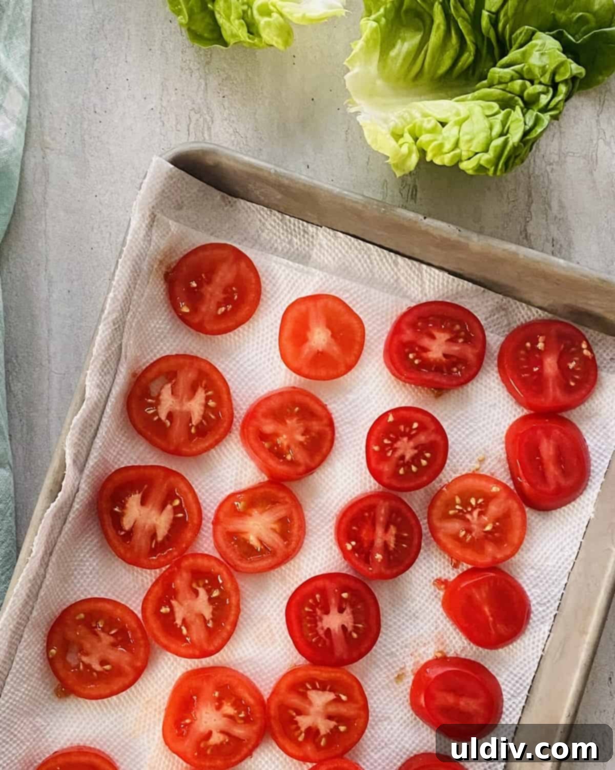 Bite-Sized BLT Sandwiches 5 Slices of tomatoes draining on a paper towel lined baking sheet.