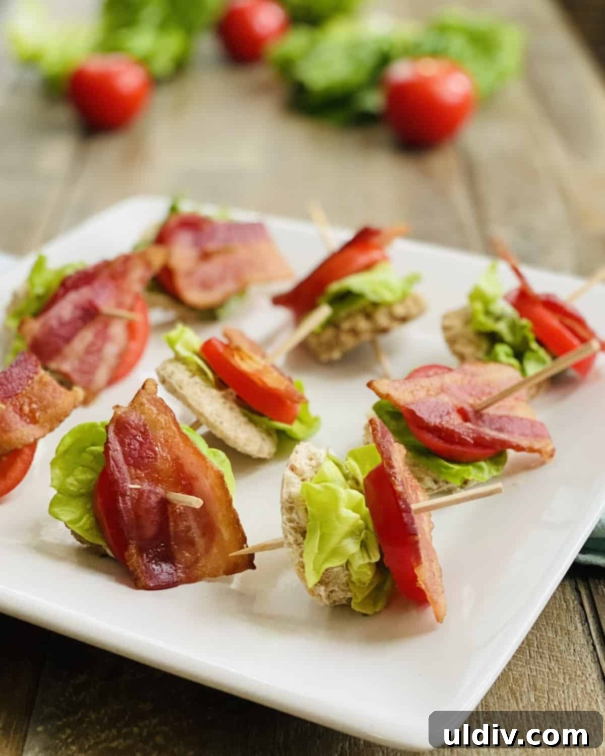 Mini BLT Sandwiches 9 A white platter with bacon, lettuce and tomato appetizers.