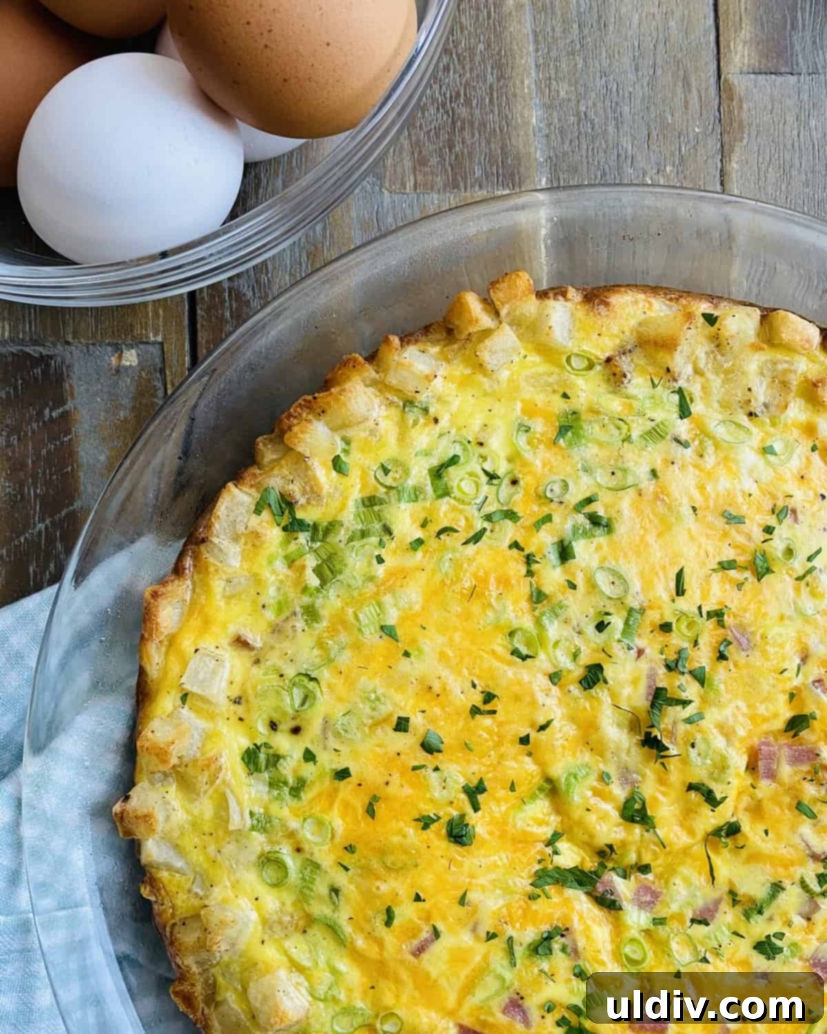 Golden Hash Brown Quiche: Ham and Cheese Delight 2 A whole hash brown crust quiche with ham and cheddar, ready to be sliced.