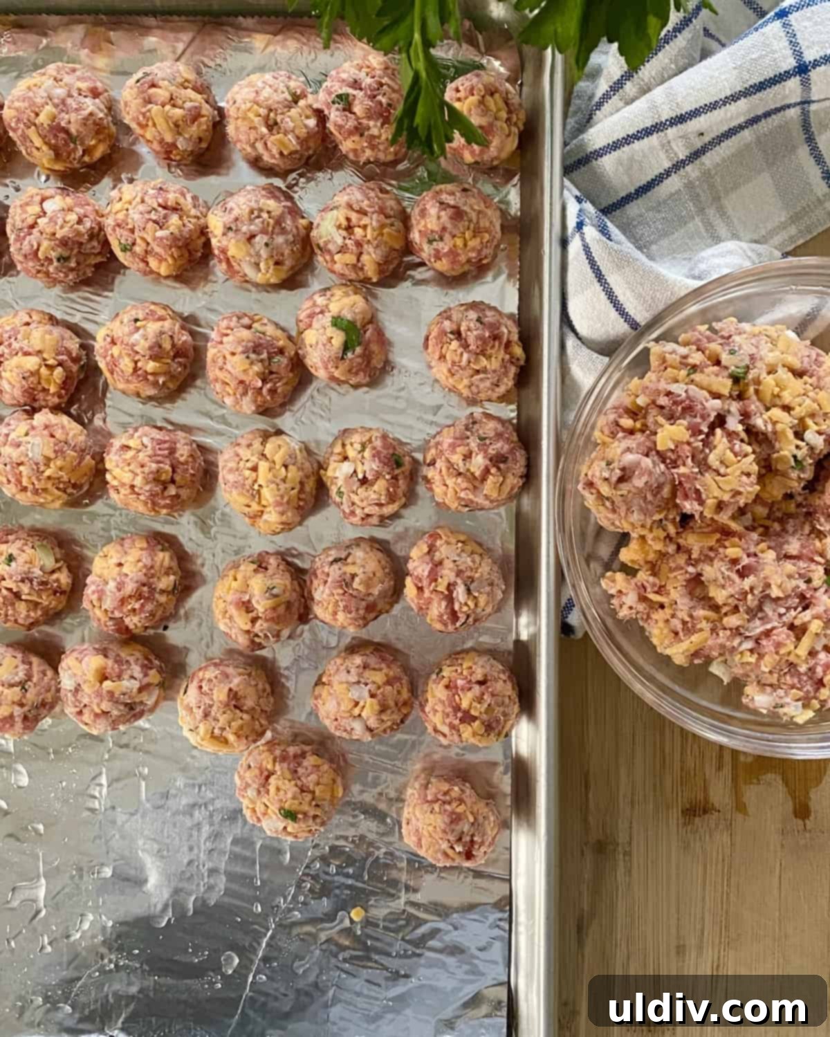 Grandma's Cheesy Bisquick Sausage Bites 7 Unbaked sausage balls on a baking sheet.