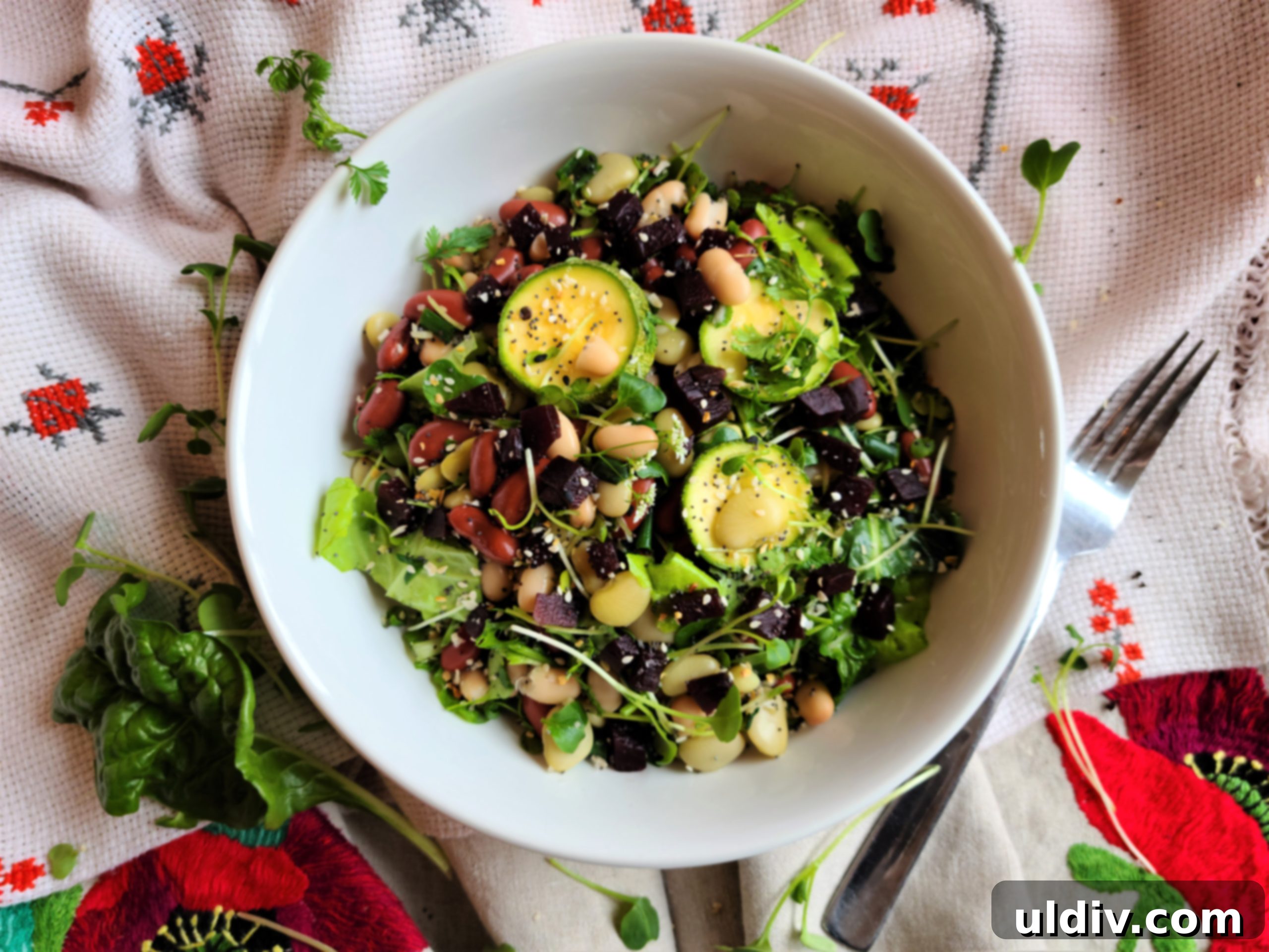 Red White and Green Vegan Fourth of July Salad 2 A vibrant, colorful vegan salad featuring navy, red kidney, and lima beans mixed with fresh zucchini slices, pickled beets, and an abundance of leafy greens. It's presented in a large, inviting bowl, perfect for a festive 4th of July gathering.