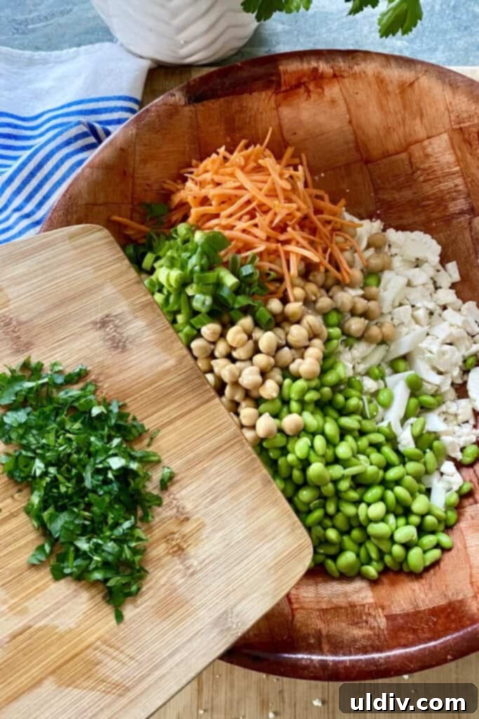 Vegetarian Cauliflower Salad with Edamame and Chickpeas 6 chopped cauliflower, edamame, chickpeas, carrots and parsley for salad in a bowl
