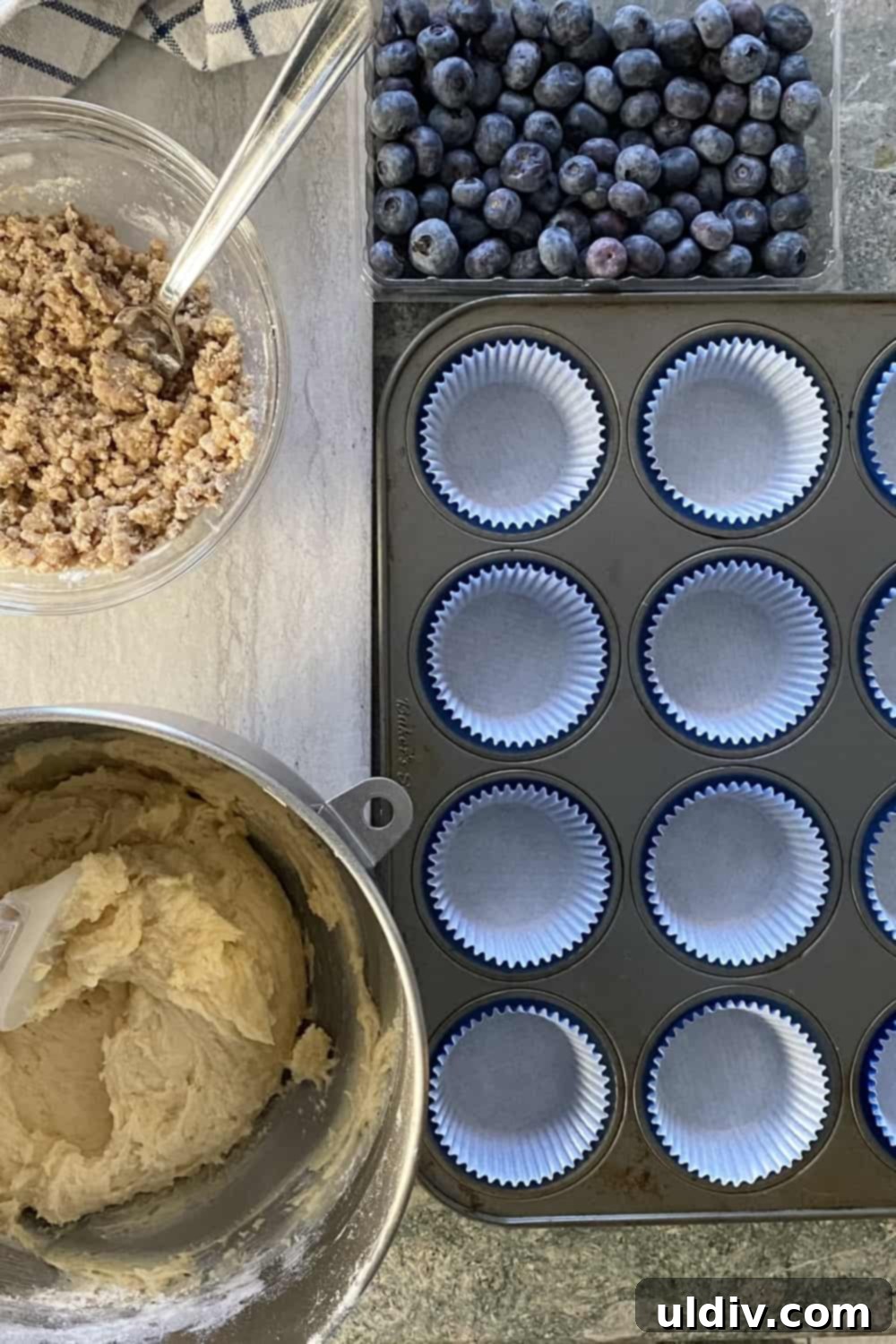 Signature Coffee Cake Muffins 5 Prepared muffin batter and a muffin tin carefully lined with baking cups, ready for filling.