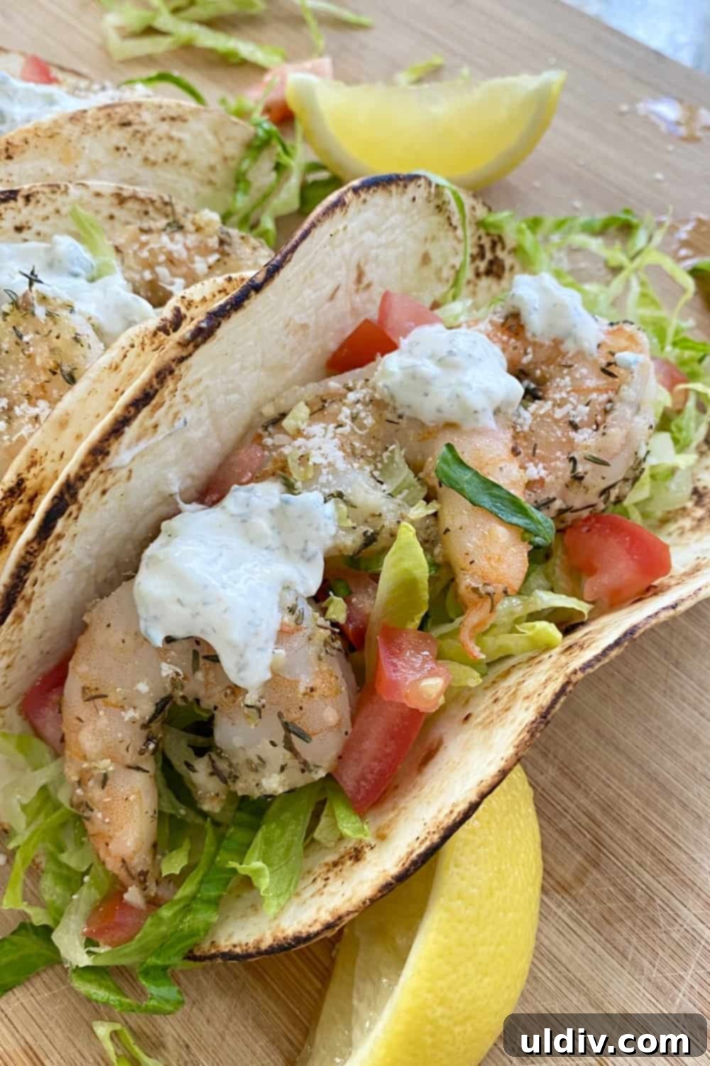 Sun-Kissed Mediterranean Shrimp Tacos with Zesty Tzatziki 2 A vibrant Mediterranean Shrimp Taco featuring roasted Parmesan shrimp, fresh shredded lettuce, diced tomatoes, and a creamy tzatziki sauce, nestled in a soft tortilla.