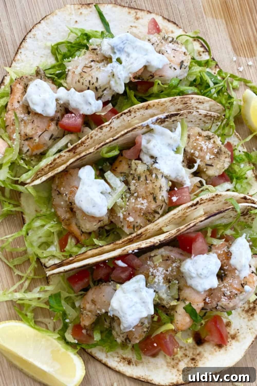 Sun-Kissed Shrimp Tacos with Zesty Tzatziki 8 Three Mediterranean shrimp tacos artfully arranged on a rustic cutting board, showcasing their vibrant colors and creamy tzatziki sauce.