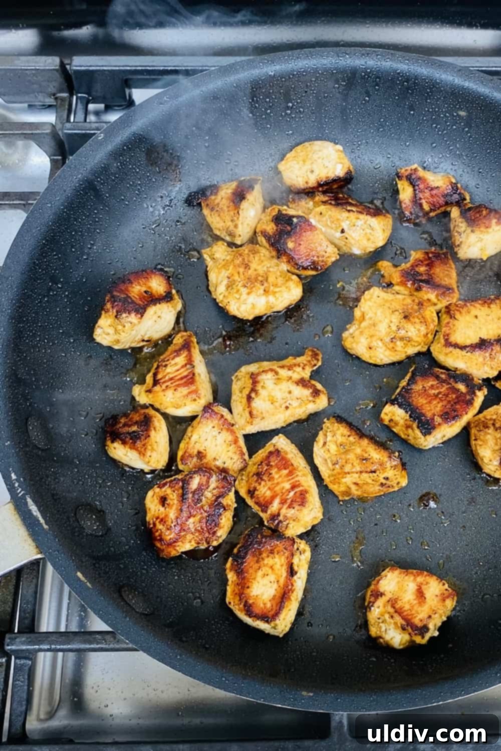 Perfectly Succulent Lemon Herb Chicken 6 Seared and charred lemon herb chicken in a nonstick pan, showing the cooking process.