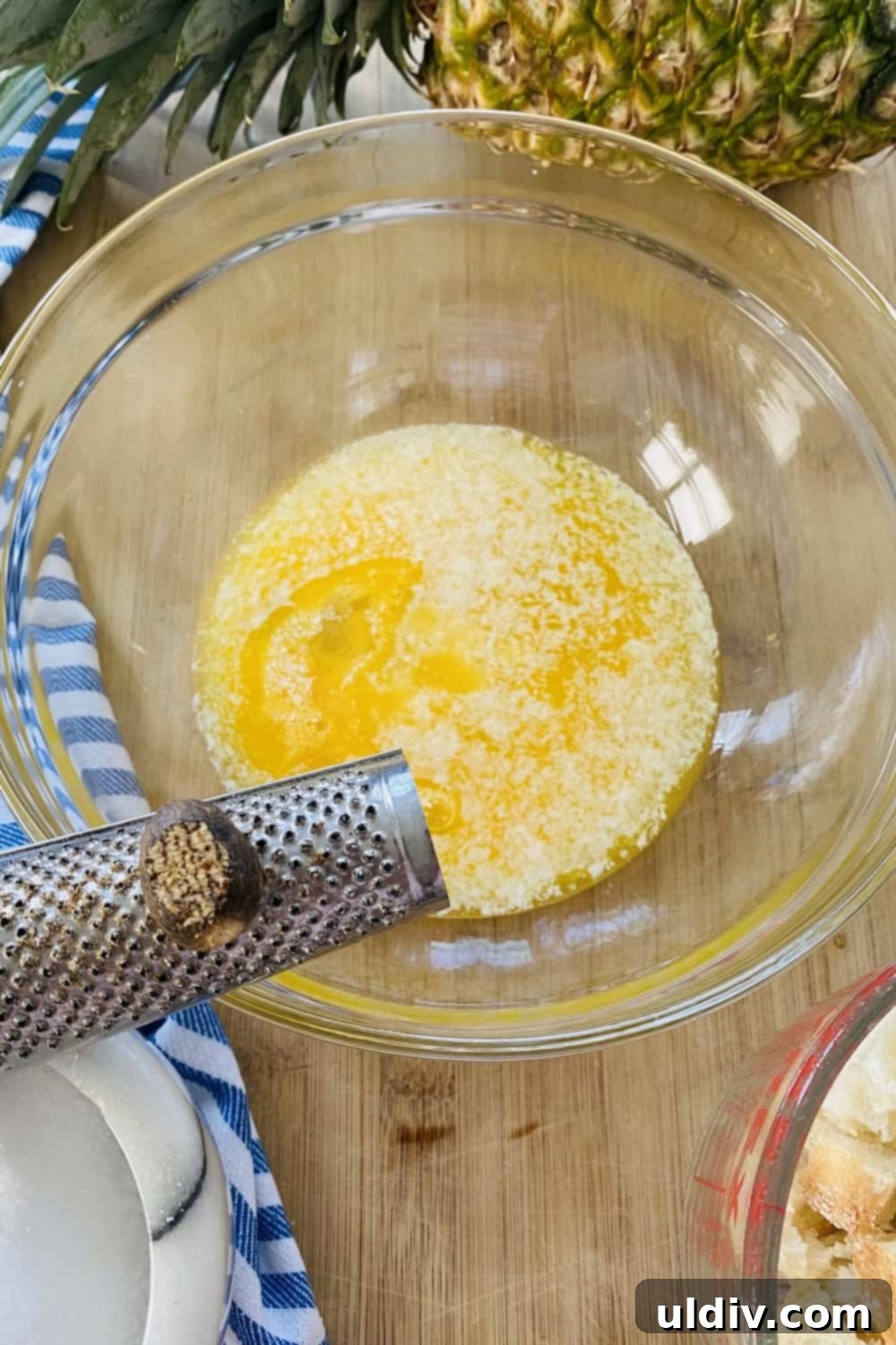 Tropical Pineapple Bread Pudding 5 Grating nutmeg into a bowl of melted butter.