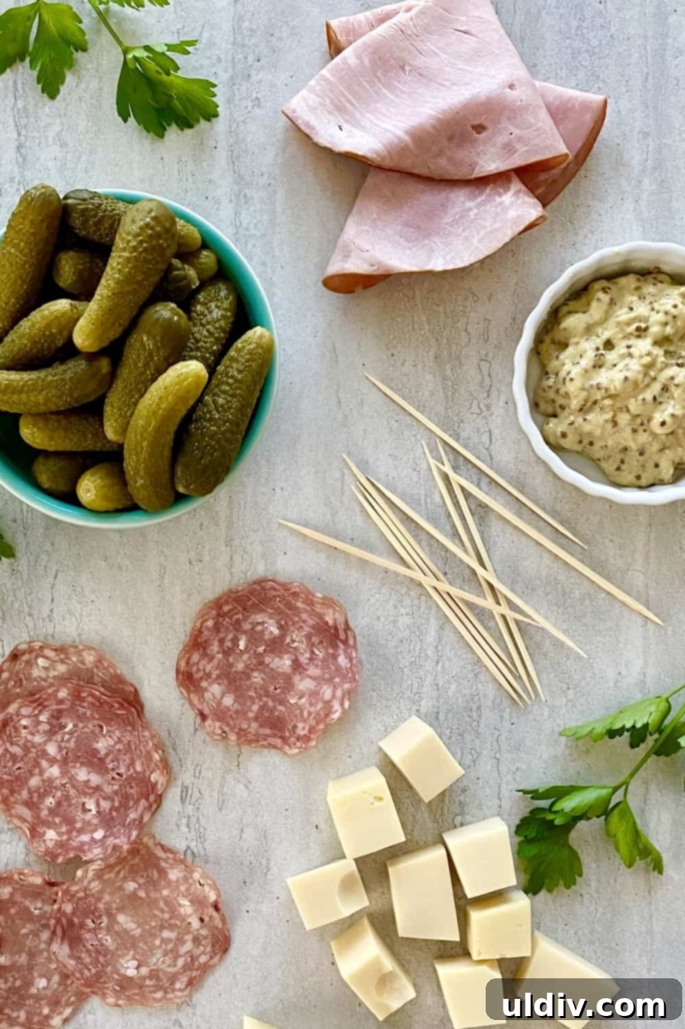 Cuban Skewer Bites 3 Ham slices, Swiss cheese, salami, dill pickles, mustard on a marble counter.
