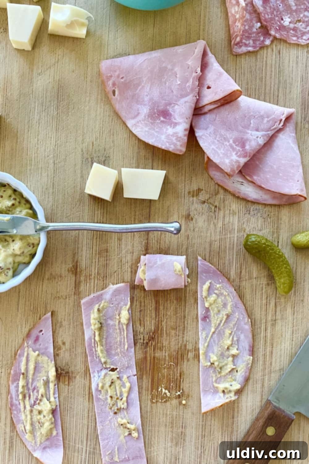 Cuban Skewer Bites 4 Strips of ham spread with mustard with small pickles and cheese cubes.