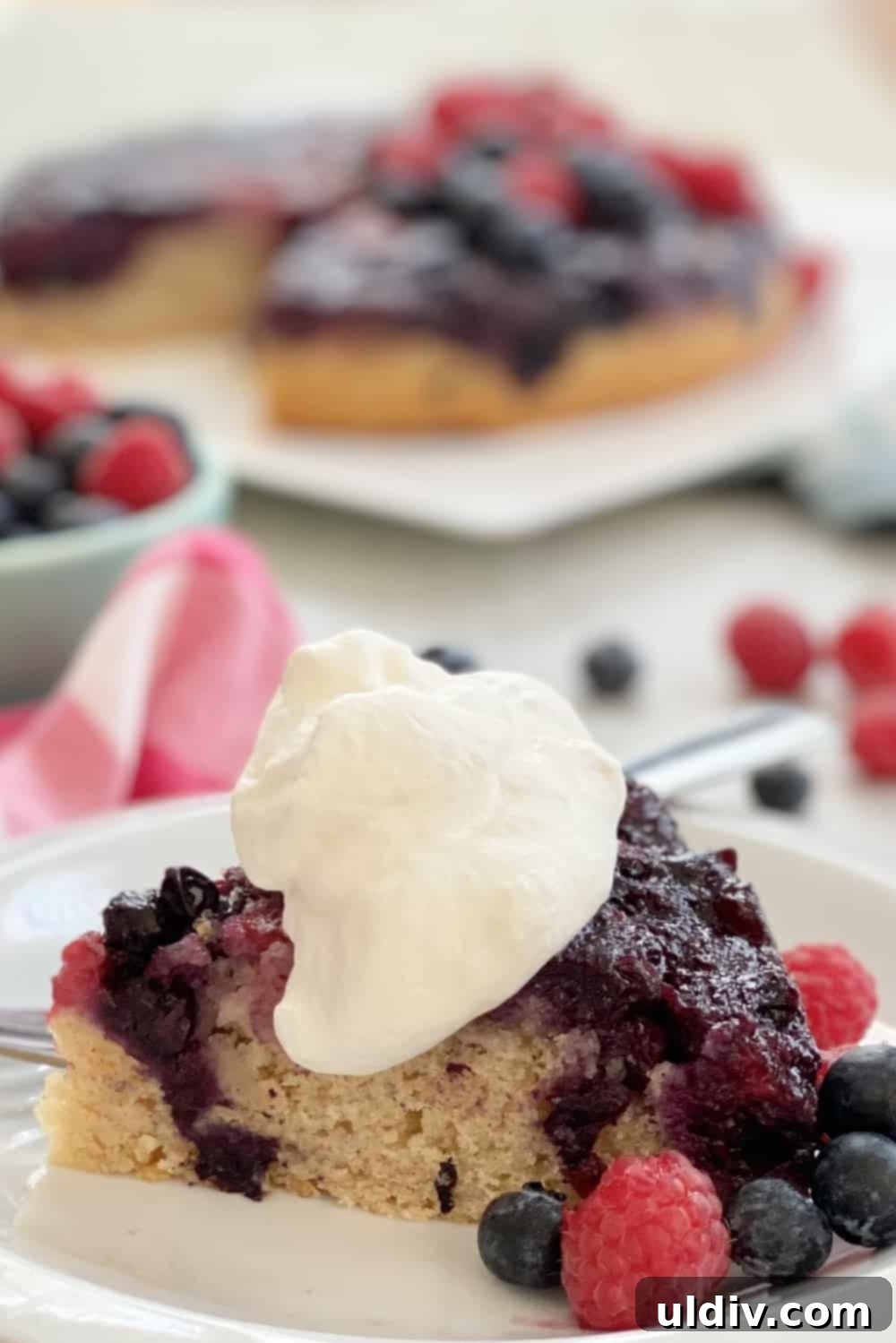 Jeweled Berry Inversion Cake 2 A beautifully presented slice of Double Berry Upside Down Cake, showing the vibrant berry layer at the top.