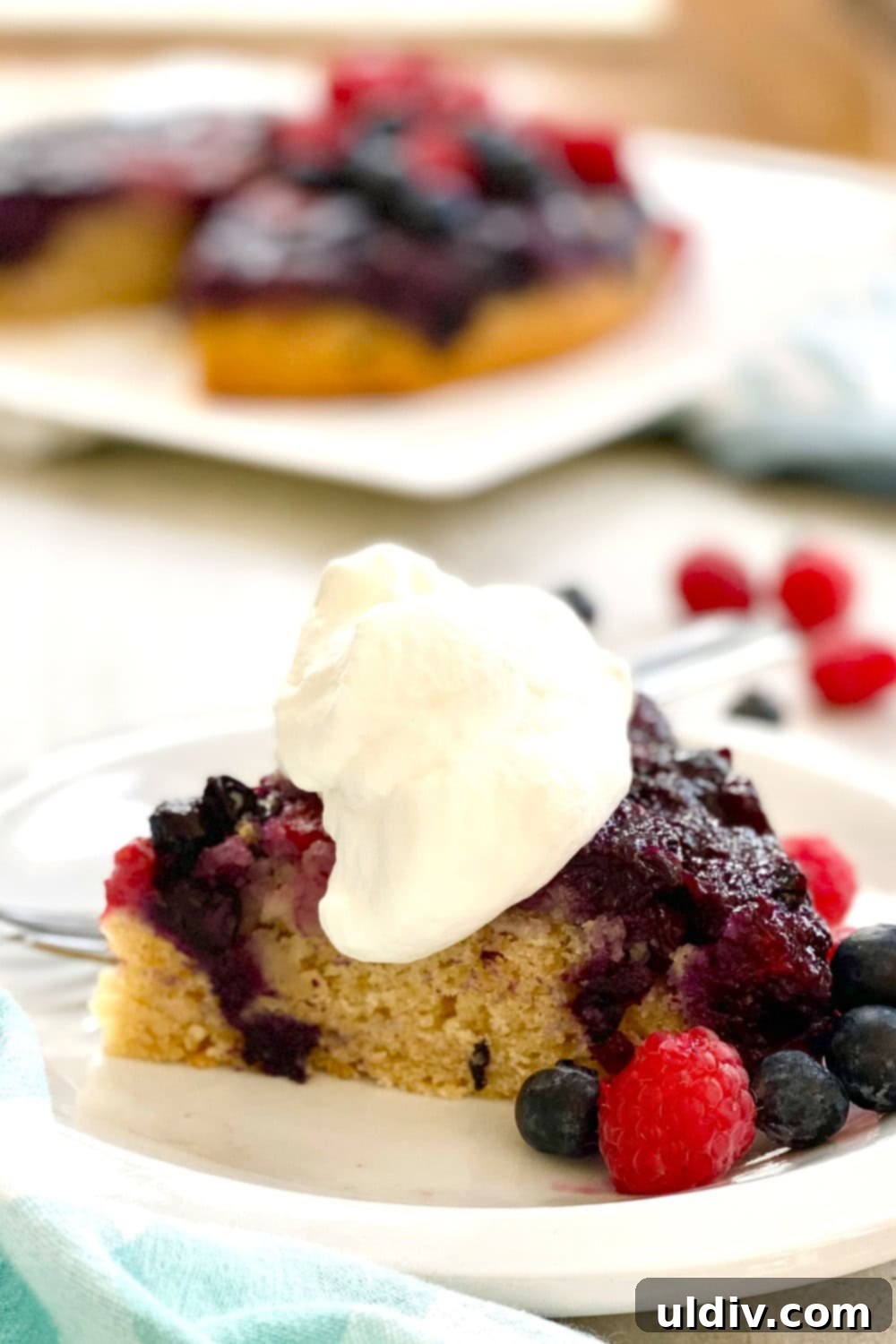 Berry Burst Upside Down Cake 8 A slice of upside down cake served with a dollop of homemade whipped cream.