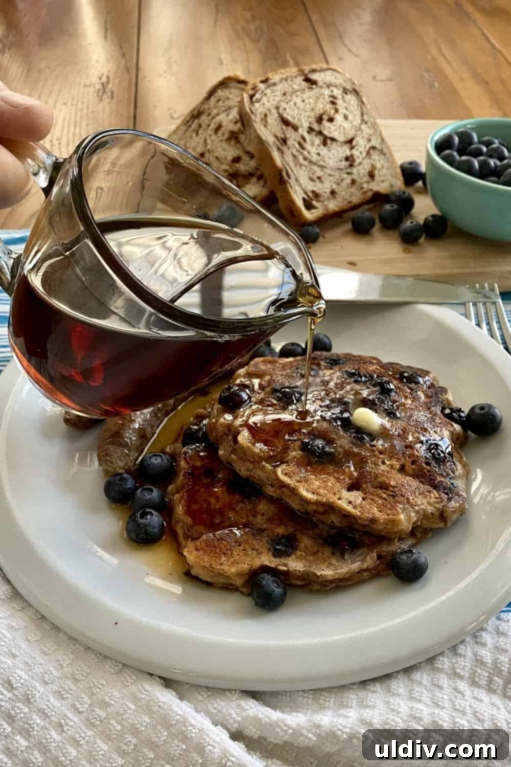 Golden French Toast Pancakes drizzled with maple syrup and fresh blueberries