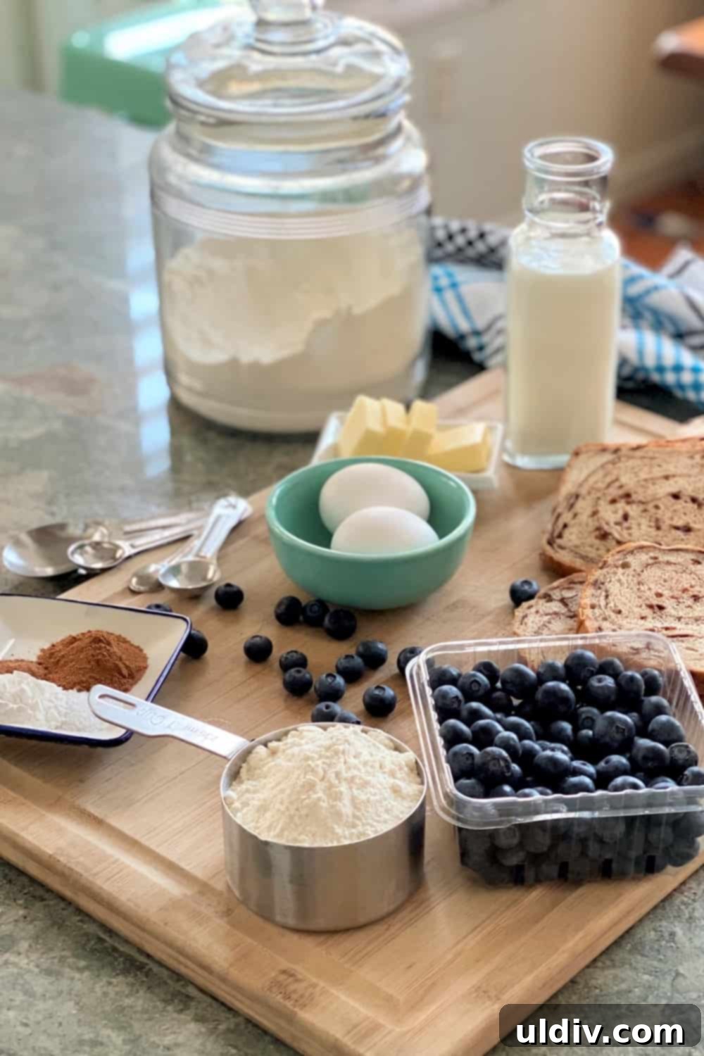 Essential ingredients for blueberry bread pudding pancakes: eggs, flour, blueberries, milk, butter
