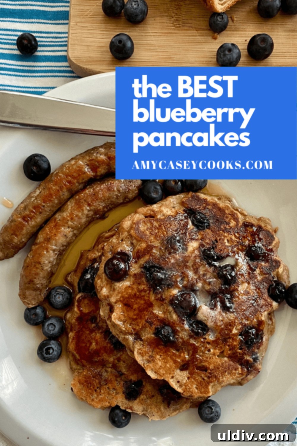 Stacked blueberry pancakes with breakfast sausage on the side, ready to serve
