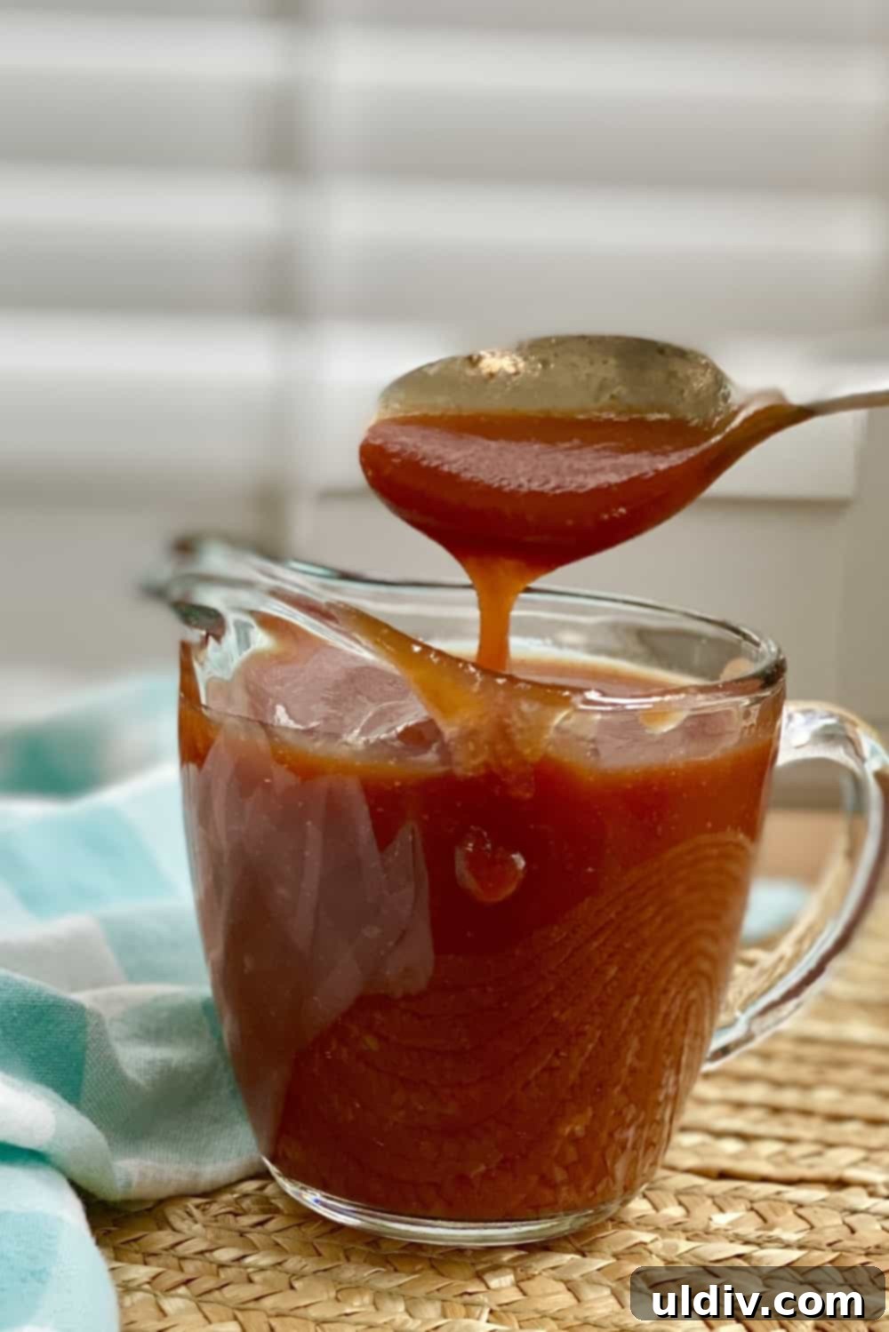 Easy Homemade BBQ Sauce 2 A spoon generously coated with homemade barbecue sauce, showcasing its rich texture and inviting color.