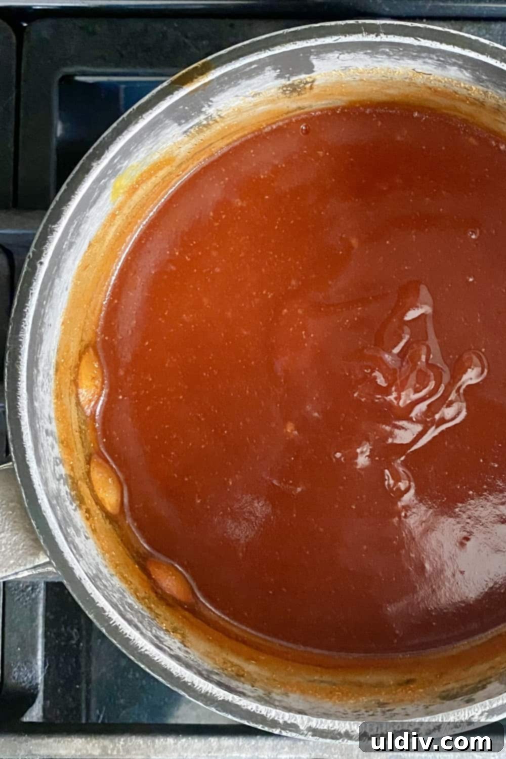 Simply Delicious Homemade BBQ Sauce 7 A small saucepan filled with rich, bubbling homemade BBQ sauce, simmering gently on the stovetop, indicating its readiness.