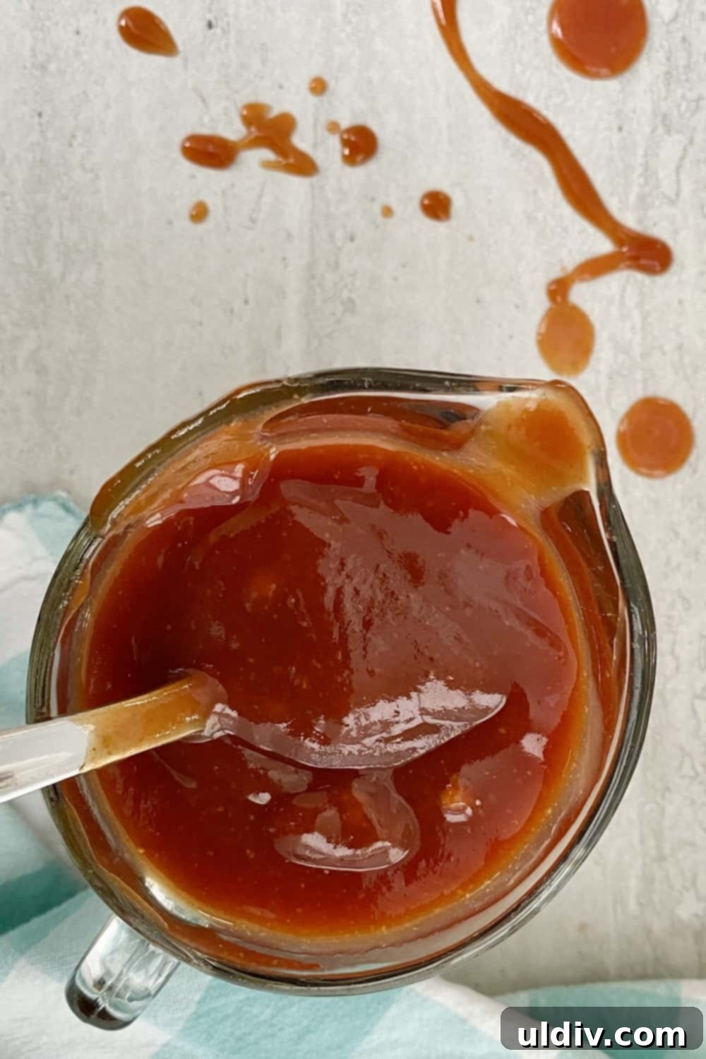 Easy Homemade BBQ Sauce 8 A small glass pitcher brimming with freshly made, simple homemade BBQ sauce, ready to be used or stored.