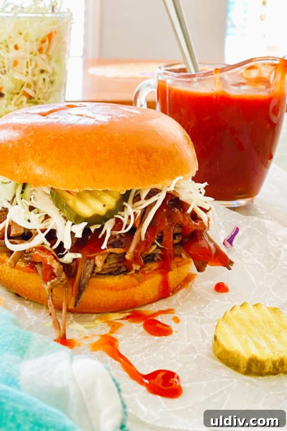 Tender Instant Pot BBQ Brisket Sandwiches 2 Close-up of a delicious BBQ brisket sandwich with shredded beef, coleslaw, and pickles on a brioche bun.