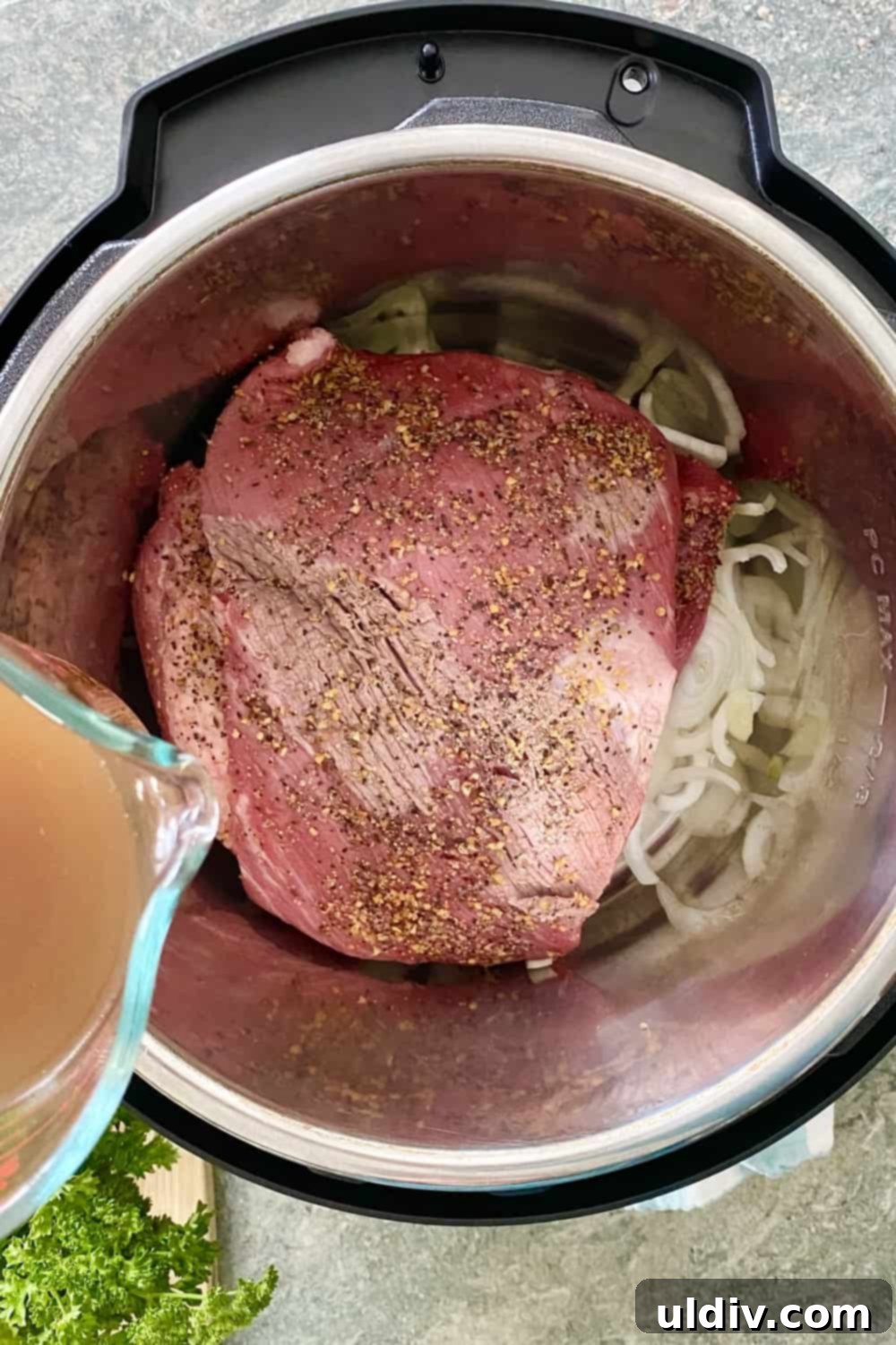 Tender Instant Pot BBQ Brisket Sandwiches 6 Adding beef broth to an Instant Pot containing seasoned brisket and sliced onions.