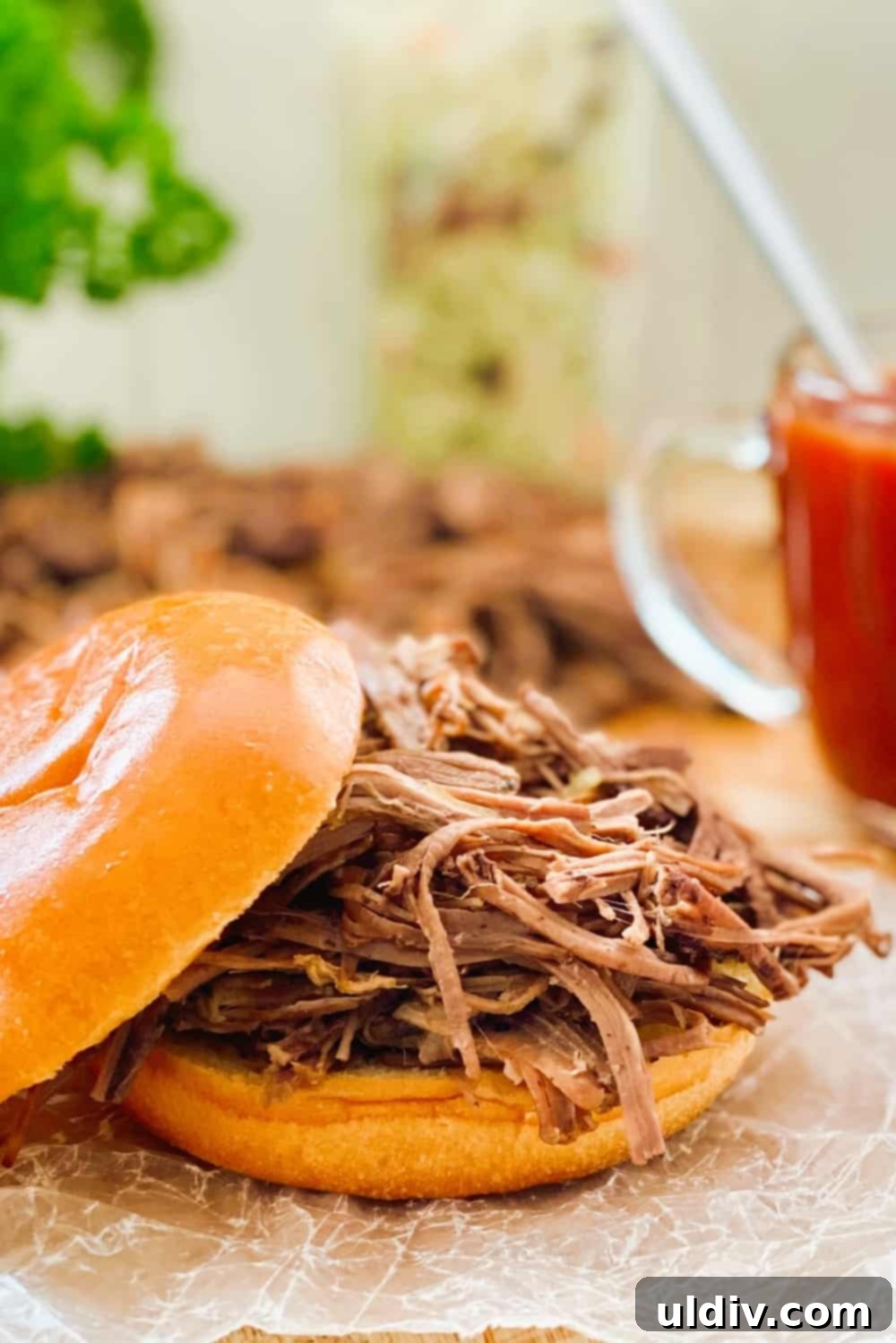 Tender Instant Pot BBQ Brisket Sandwiches 9 A perfectly assembled Instant Pot BBQ Brisket Sandwich on a brioche roll, showcasing the layers of meat, sauce, and coleslaw.