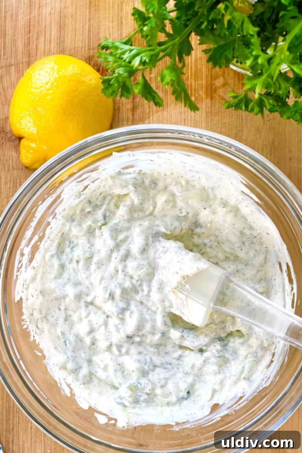 Versatile Easy Tzatziki Sauce 7 tzatziki sauce in a bowl with a rubber spatula.