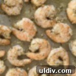 Golden Parmesan Roasted Shrimp: Simply Delicious 11 Baked garlic shrimp with cheese on a baking sheet, ready to be served.