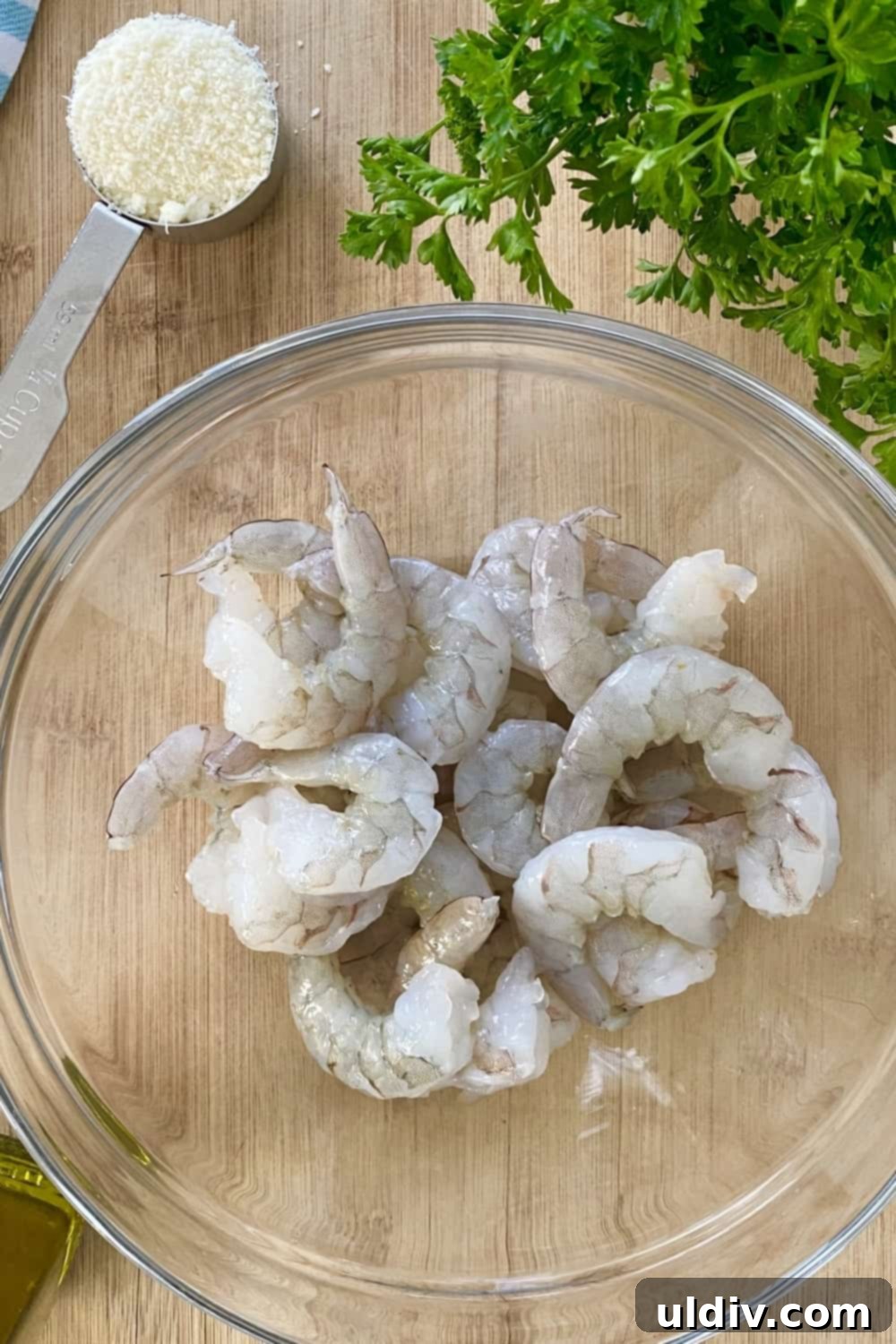 Crispy Parmesan Roasted Shrimp 3 Raw shrimp in a bowl on a cutting board.