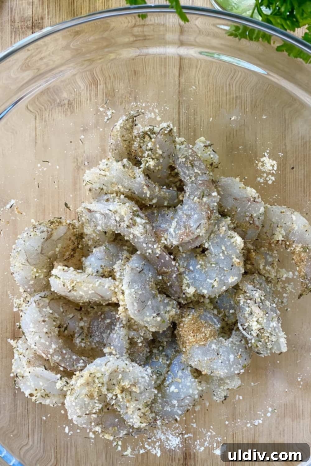Crispy Parmesan Roasted Shrimp 6 Shrimp tossed with seasonings in a glass bowl.