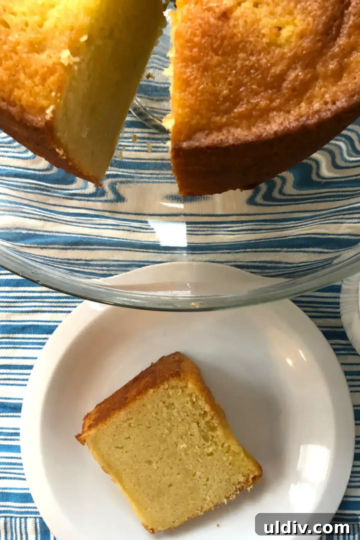 Classic Vanilla Pound Cake 7 A whole pound cake with a slice removed, showcasing its moist interior.